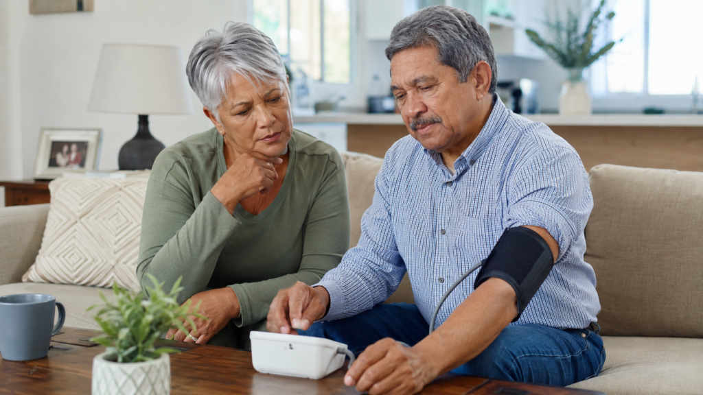 Senior couple looking at a home blood pressure monitor with concern.
